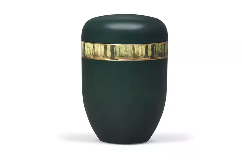 Blaue Urne mit Waldmotiv vor weißem Hintergrund